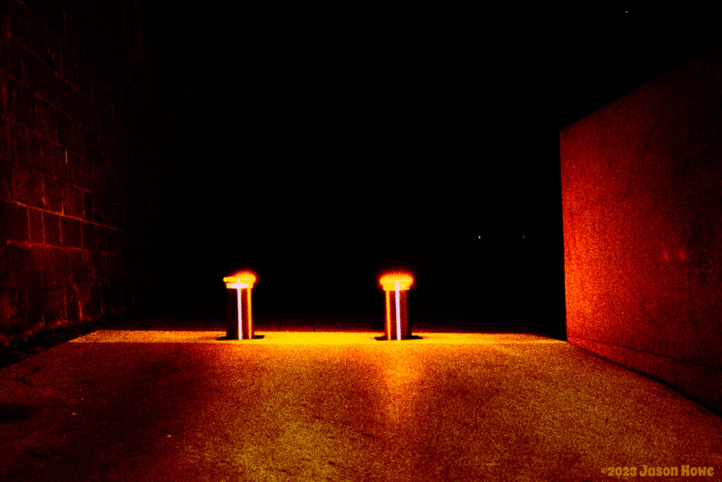 ominous red lights on parking bollards at night.