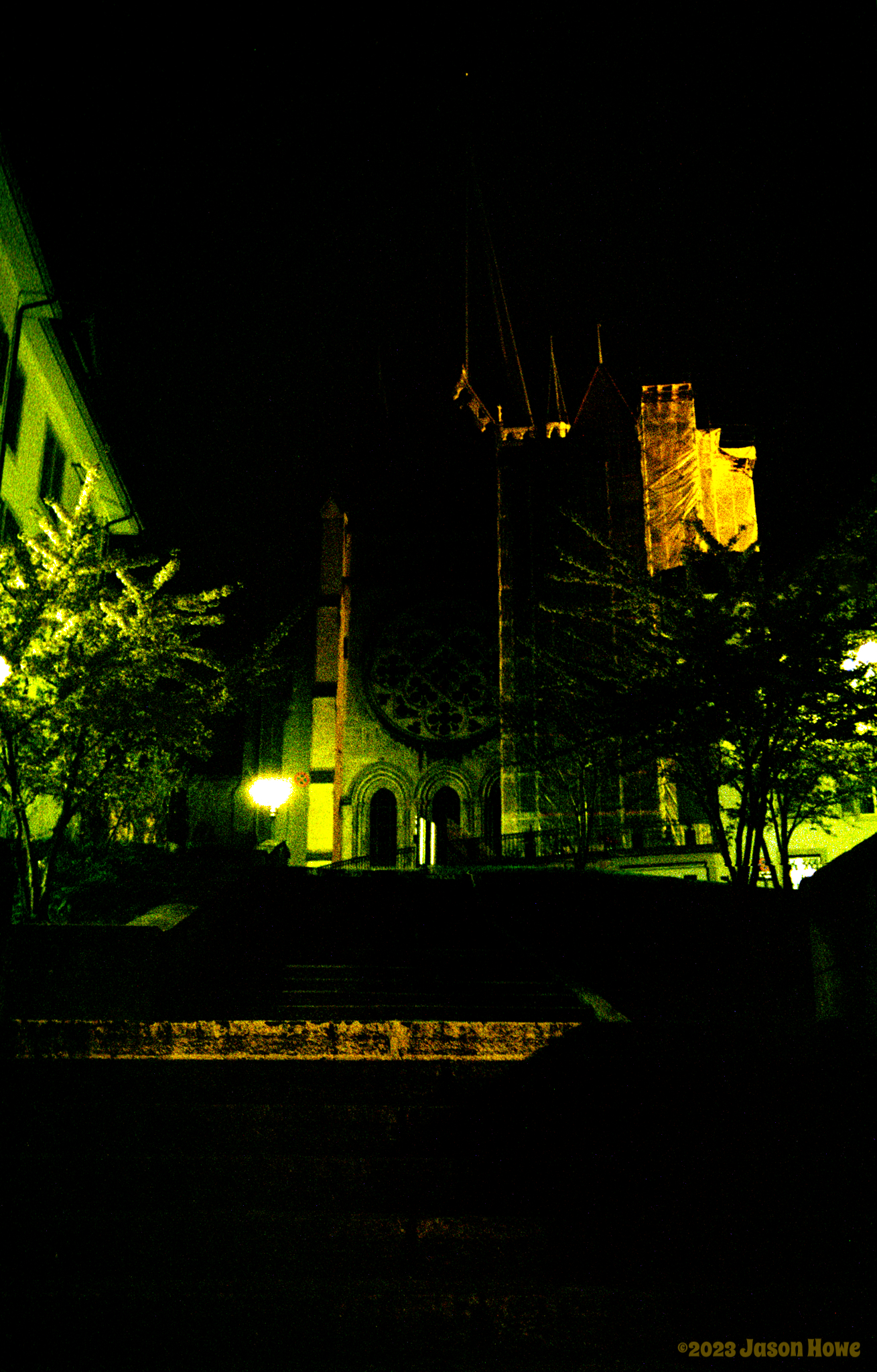 Night time picture of dark steps climbing up to a partially lit medieval cathedral