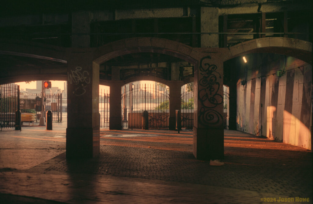 Early morning light, showing through the archways of a gratified underpass.